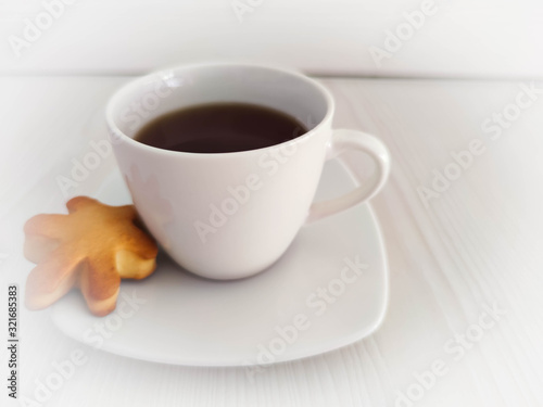 A white cup of tea or coffee and saucer on the wooden table with copy space. A photo for a café or restaurant menu or package backdrop.