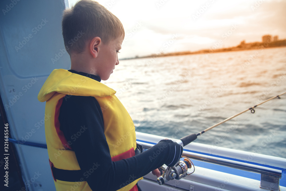 little boy caught fish spinning from a boat at sea. little boy caught fish spinning from a boat at sea.