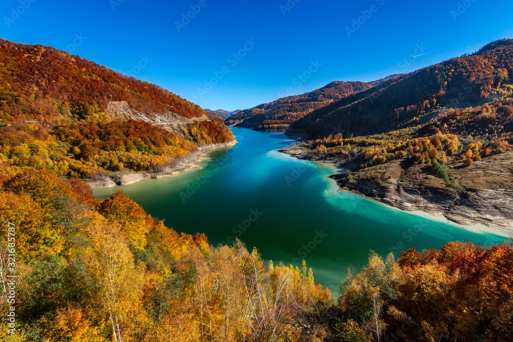 Beatiful autumn landscape with golden colored trees on the shores of Siriu lake, Siriu Dam, Buzau River Valley