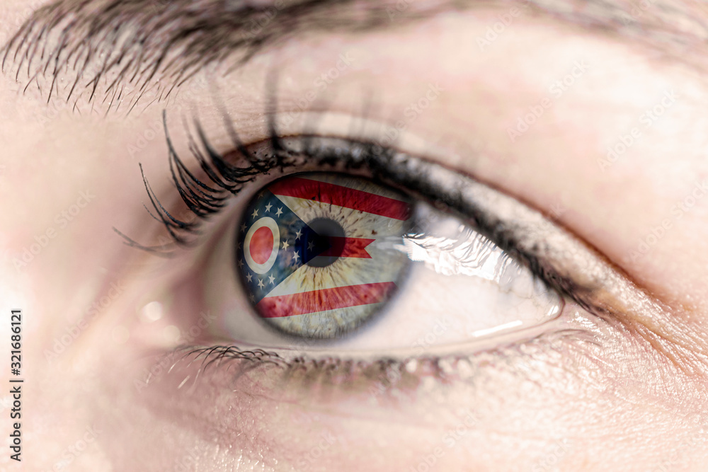 Obraz premium Flag of ohio state of the United States of America reflects in a man brown eye - election, sport, hope, young, generation, american football, basket 