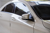 Rear-view mirror or door mirror closed for safety at car park, Side mirror of gray car , black tinted glass 