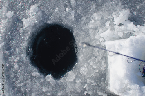 Looking down the ice fishing hole above the ice fishing pole. 
