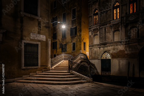 Venedig bei Nacht: eine kleine Steinbrücke unter einem Straßenlicht