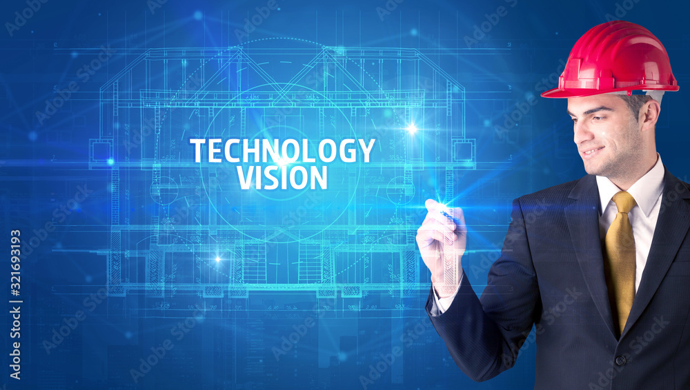 Handsome architect with helmet drawing TECHNOLOGY VISION inscription, new technology concept Handsome architect with helmet drawing TECHNOLOGY VISION inscription, new technology concept