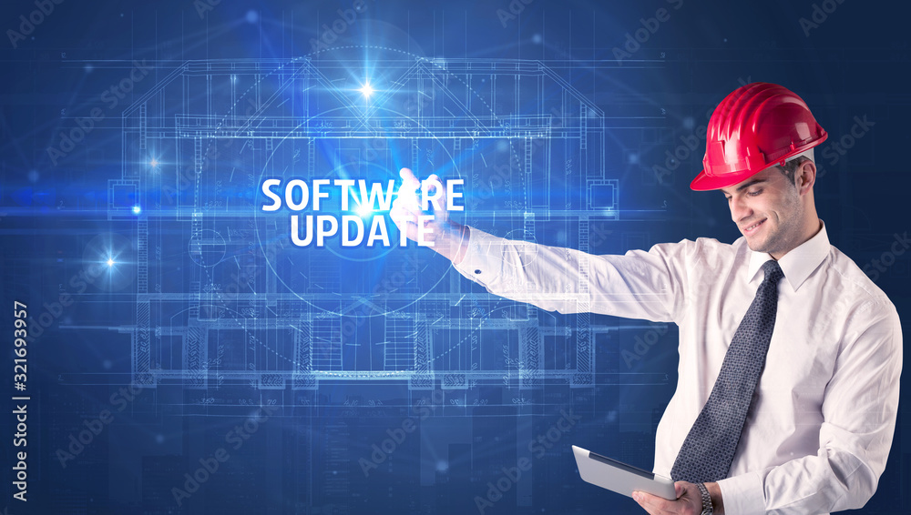 Handsome architect with helmet drawing SOFTWARE UPDATE inscription, new technology concept