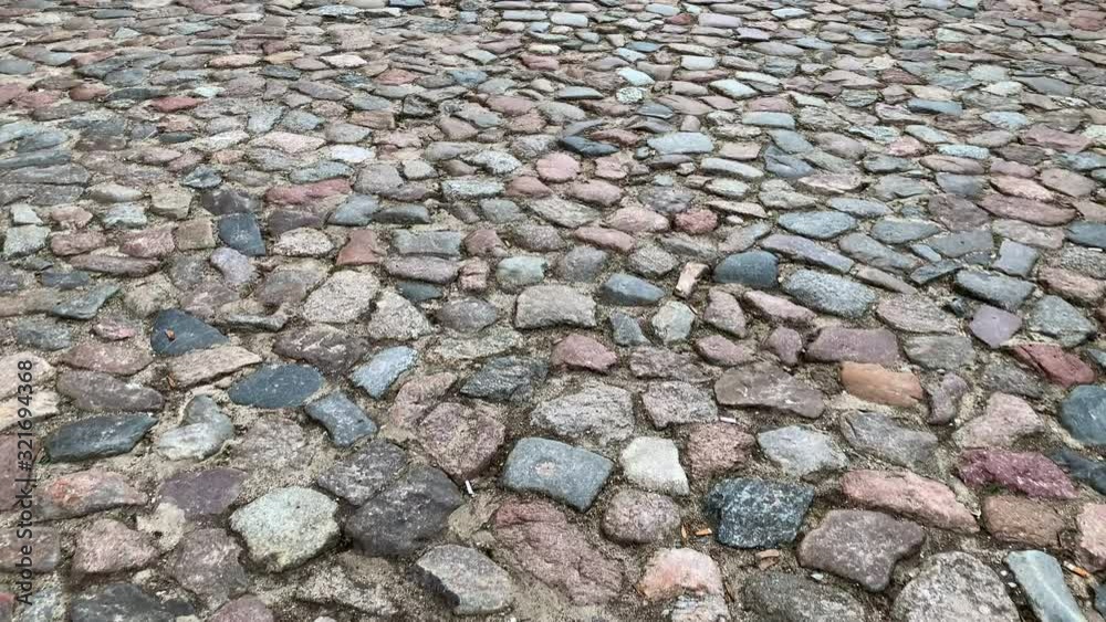 Moving on an ancient stone pavement in perspective. Old stone pavement texture. Handmade path with concrete and rocks. Pavement street with one shaft. Moving on an ancient stone pavement in perspective. Old stone pavement texture. Handmade path with concrete and rocks. Pavement street with one shaft.