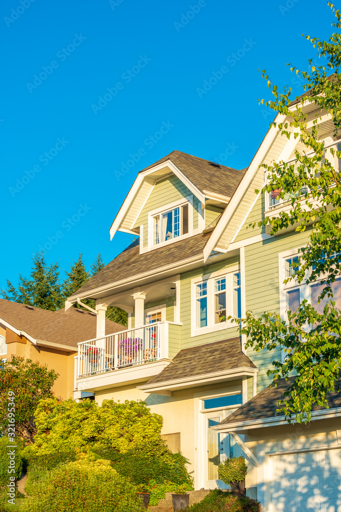 A perfect neighborhood. Houses in suburb at Summer in the north America. Top of a luxury house with nice window over blue and white sky. A perfect neighborhood. Houses in suburb at Summer in the north America. Top of a luxury house with nice window over blue and white sky.