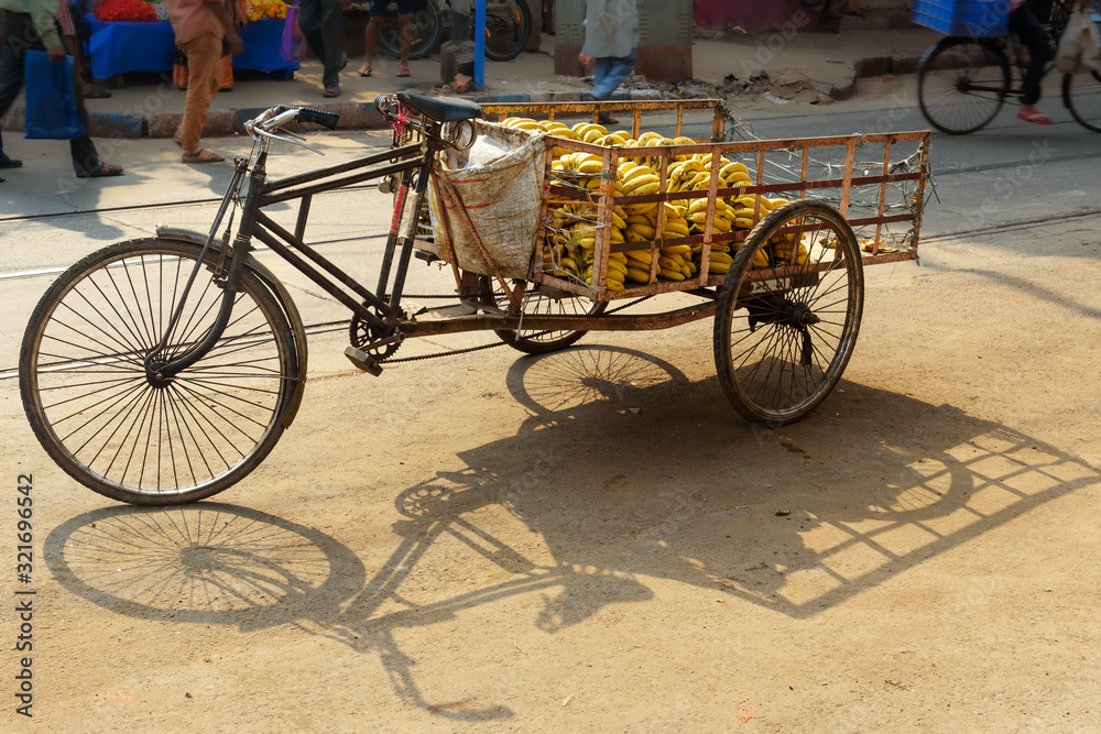 Cargo cycle rickshaw with bananas on the road. Kolkata. India