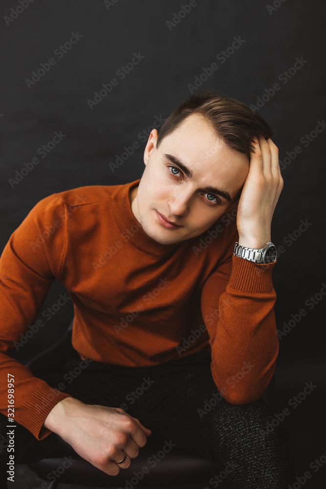 A businessman straightens the hair on his head hairstyle. Portrait of a guy in a brown sweater A businessman straightens the hair on his head hairstyle. Portrait of a guy in a brown sweater