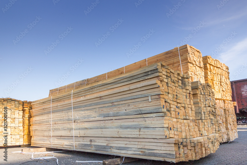 wooden boards are stored in an open warehouse in the seaport wooden boards are stored in an open warehouse in the seaport