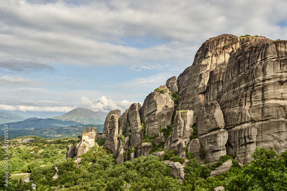 Amazing Meteora Monastery in Greece. Fantastic view at mountains and green forest against epic blue sky with clouds. UNESCO Amazing Meteora Monastery in Greece. Fantastic view at mountains and green forest against epic blue sky with clouds. UNESCO