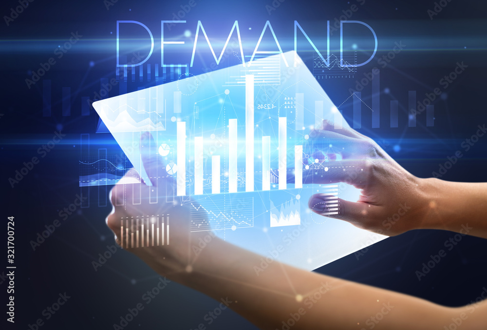 Hand holding futuristic tablet with DEMAND inscription above, modern business concept Hand holding futuristic tablet with DEMAND inscription above, modern business concept