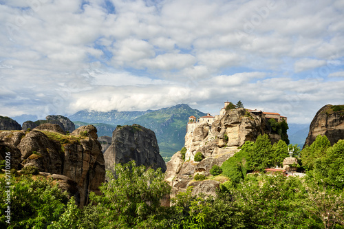 Amazing Meteora Monastery in Greece. Fantastic view at mountains and green forest against epic blue sky with clouds. UNESCO © Mindaugas