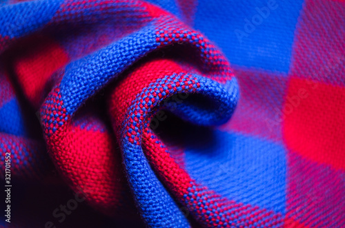 Plaid material. Red and blue cage clothes. Crumpled twisted fabric background