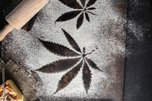 on white flour traces of cannabis leaves can be seen rusty surface near a battledore lies on a burlap lies a pie