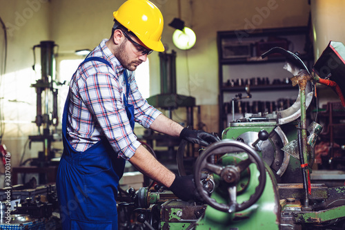 Turner worker is working on a lathe machine in a factory.   © zorandim75