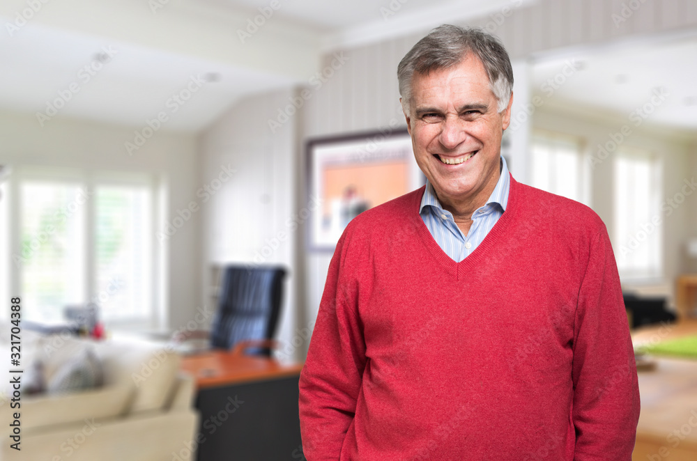Smiling mature man at home in his living room Smiling mature man at home in his living room