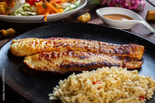 Foto Pescado a la plancha con especias y ensalada de lechuga zanahoria y aderezo mil