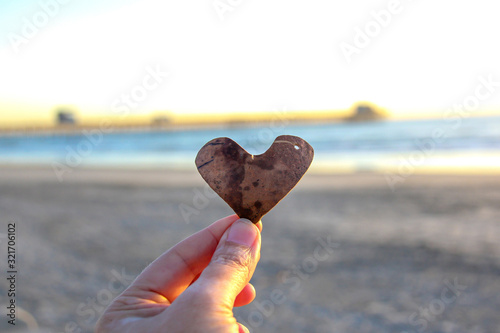 Fotografia Hand holding heart in front of the ocean and pier in Oceanside California