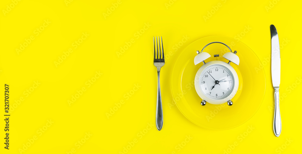 Alarm clock with fork and knife on the table. Time to eat, Breakfast, Lunch  Time and Dinner concept Photos | Adobe Stock