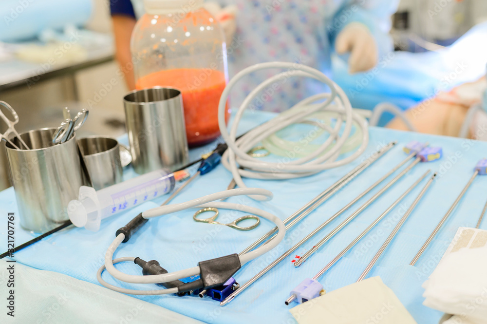 Plastic surgery to remove excess fat. Pumping fat into a jar during liposuction. Surgical instruments for liposuction in the operating room. Plastic surgery to remove excess fat. Pumping fat into a jar during liposuction. Surgical instruments for liposuction in the operating room.