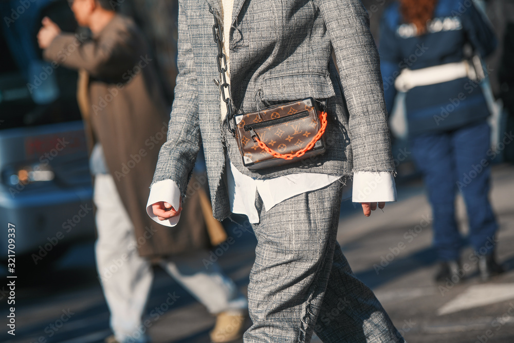 Milan, Italy – January 11, 2020: Fashionable man with Louis Vuitton hand bag,  street style outfit. Stock Photo