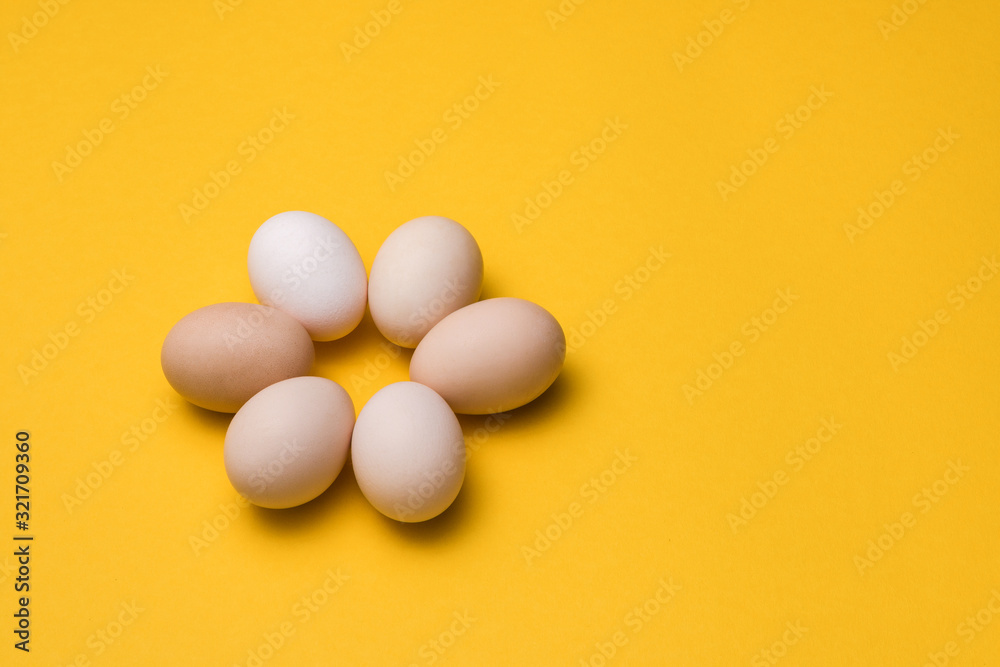 natural ecological eggs in shape of flower on yellow background with copy space. happy easter