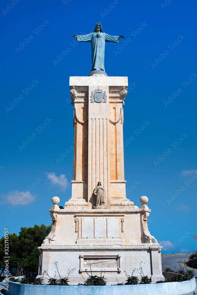 old statue of jesus on pillar in menorca, spain