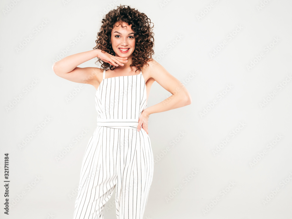 Portrait of beautiful smiling model with afro curls hairstyle dressed in summer hipster clothes.Sexy carefree girl posing in studio on gray background.Trendy funny and positive woman Portrait of beautiful smiling model with afro curls hairstyle dressed in summer hipster clothes.Sexy carefree girl posing in studio on gray background.Trendy funny and positive woman