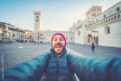 happy man tourist take selfie photo in Piazza del Duomo central square in Trento. Trento is a city on the Adige River in Trentino Alto Adige Sudtirol in Italy.