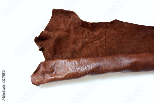 Leather in roll isolated on white background. Piece of brown leather isolated on white