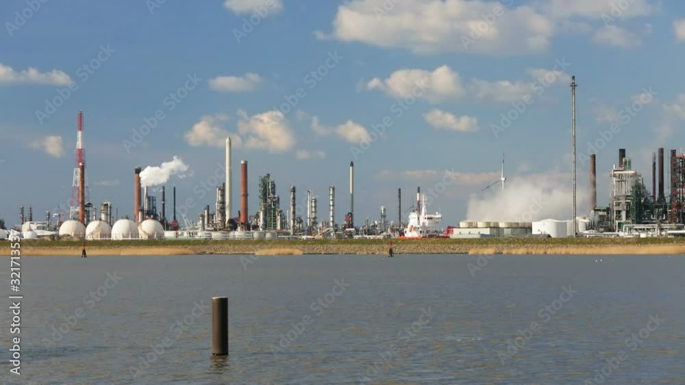 A large oil refinery in the harbor of Antwerp, Belgium with perfect blue sky. A large oil refinery in the harbor of Antwerp, Belgium with perfect blue sky.