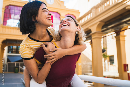 Fotografía Loving lesbian couple having fun at the street.