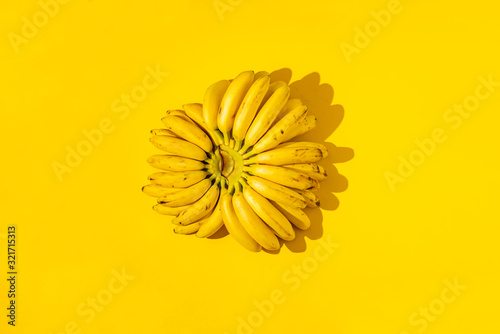 ripe trendy ready to eat ugly bunch of mini bananas with black dots on yellow surface