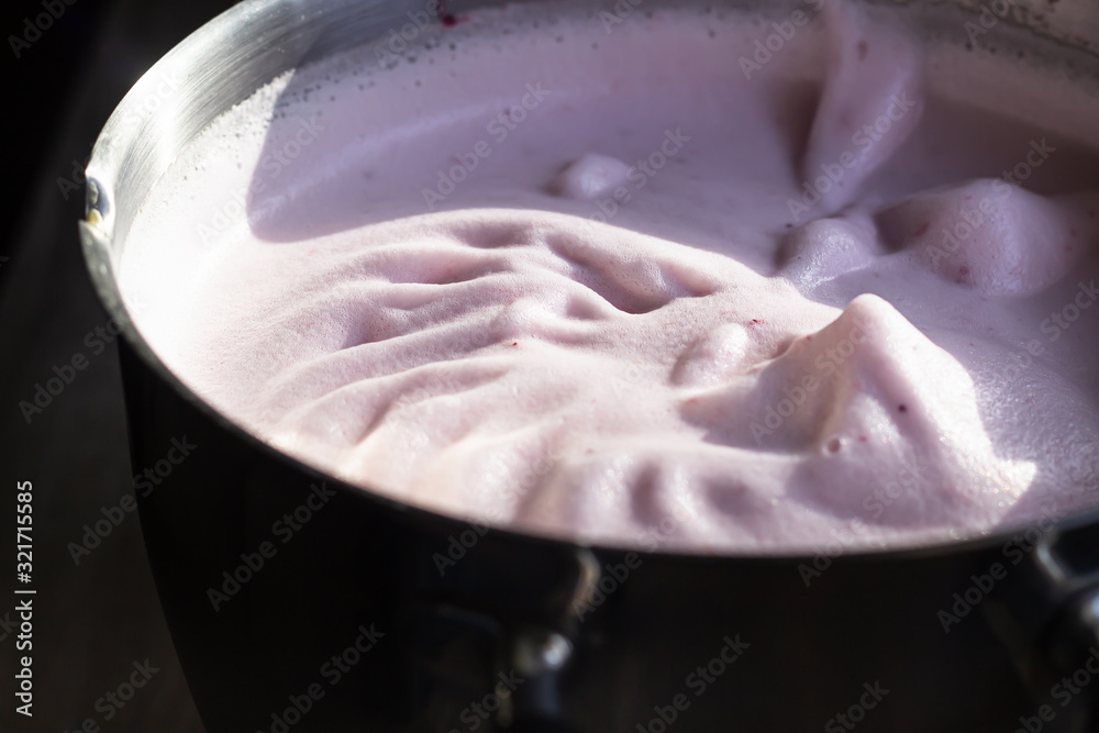 Pink strawberry milkshake or cocktail texture. Pink bubbles of berry drink froth. Trendy style with artistic shadows. Close up.