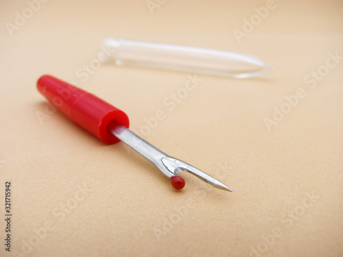 sewing tools. seam ripper on a beige background