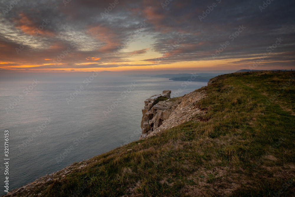 Beautiful vibrant sunset over sea and clifftop