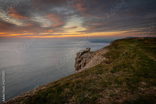 Beautiful vibrant sunset over sea and clifftop © Donna White