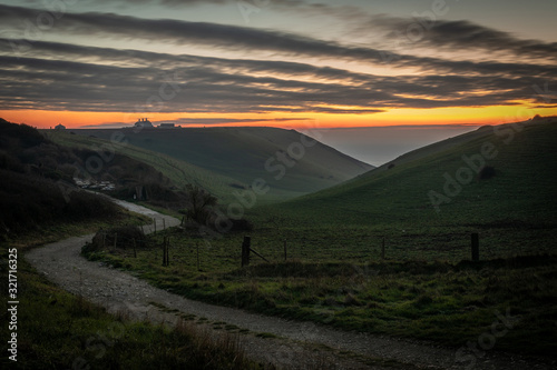 Beautiful vibrant sunset over country road and clifftop