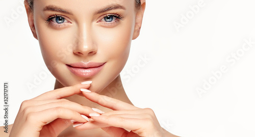 Beautiful young woman with clean fresh skin touching her face . Girl facial  treatment   . Cosmetology , beauty  and spa . Female  model, care concept