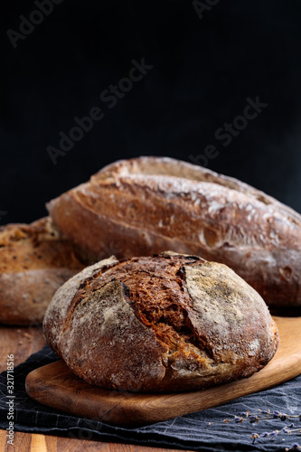 Freshly baked homemade artisan bread on wooden board. Healthy food.