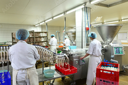 Arbeiter in einer Fleischerei - Herstellung von Würsten in einer Fabrik für Lebensmittel // worker in a butchery - production of sausages in a food factory