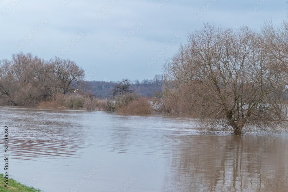 Überschwemmung und überflutete Auenlandschaft nach Hochwasser durch starke Regenfälle, Tsunami oder Schneeschmelze mit Deichbruch als extreme Wetterkapriolen mit Überflutungsgefahr