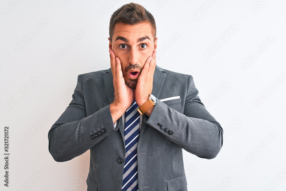 Young handsome business man wearing suit and tie over isolated background afraid and shocked, surprise and amazed expression with hands on face Young handsome business man wearing suit and tie over isolated background afraid and shocked, surprise and amazed expression with hands on face