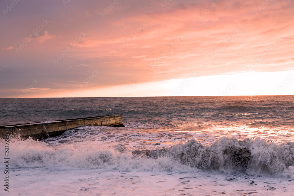Fototapeta premium The evening sea is stormy. Sea sunset. The violence of the elements. Sea foam. Incredibly beautiful colors.