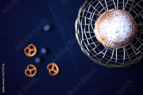 Photography Krapfen on a dark blue background with pretzels as side decor