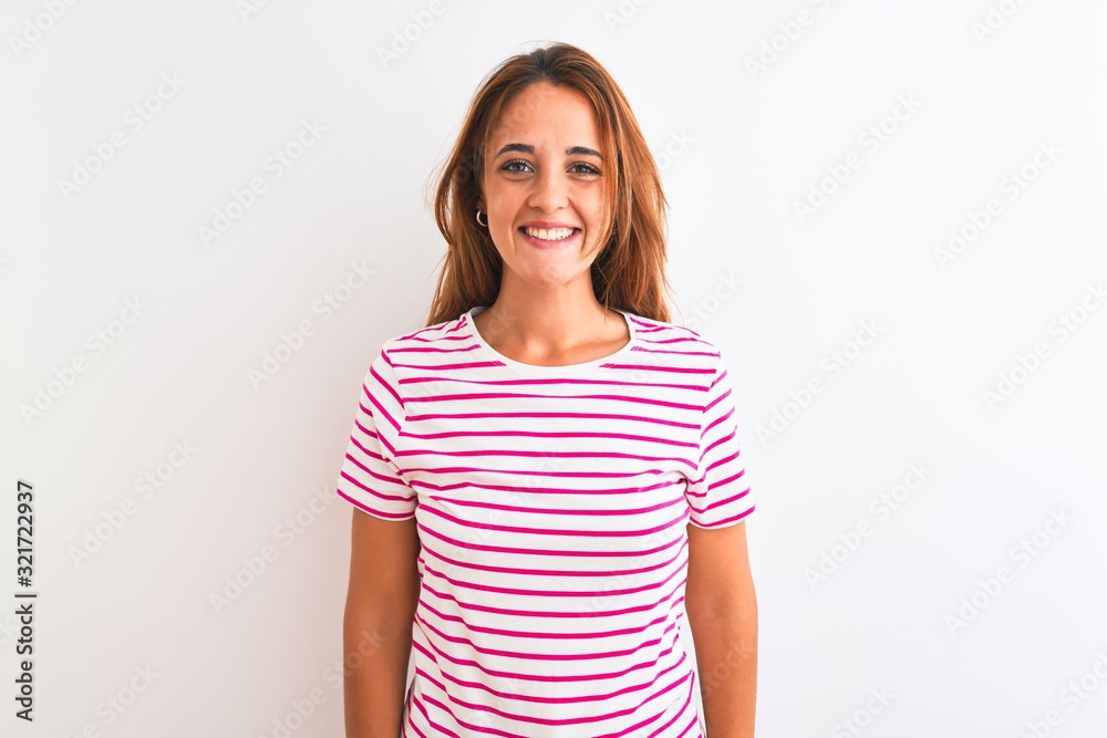 Young redhead woman wearing striped casual t-shirt stading over white isolated background with a happy and cool smile on face. Lucky person. Young redhead woman wearing striped casual t-shirt stading over white isolated background with a happy and cool smile on face. Lucky person.