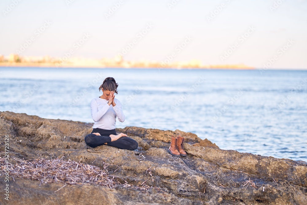 Young beautiful sportwoman practicing yoga. Coach teaching prayer pose at the beach
