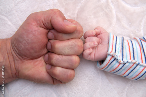 The man's hand and baby's hand.
