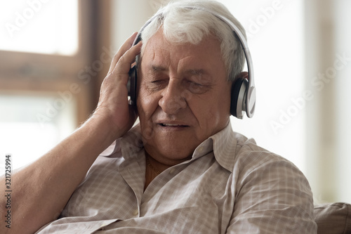 Wallpaper Mural Modern elderly man enjoy listening to music in headphones Torontodigital.ca